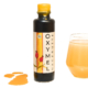Schöne Tonflasche als Geschenk mit Bienesto Oxymel mit Hagebutte (Bio, 200ml) auf weißem Hintergrund mit einem Glas eingeschenktem Oxymel als Morgenritual im Hintergrund und ein paar Tropfen Oxymel Pur.